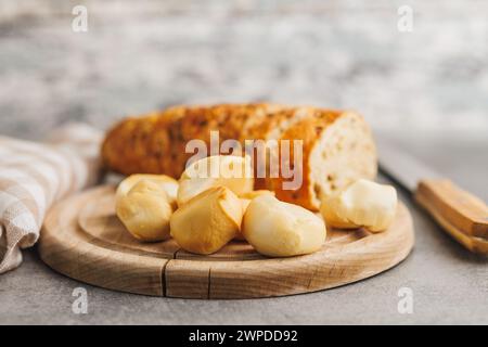 Geräucherter Mini-Scamorza-Käse. Traditioneller italienischer Käse auf Schneidebrett auf dem Küchentisch. Stockfoto