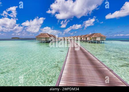 Fantastisches, sonniges Panorama auf den Malediven. Luxuriöse Resort Villen am Meer mit ruhiger Meeresbucht, glücklicher bewölkter Himmel Stockfoto