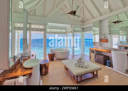 Luxuriöses Badezimmer-Innendesign im Sommerurlaub, Blick auf den blauen Himmel. Idyllisches Reisezimmer für Paare, Holzmöbel, Handtücher, Badewanne Stockfoto
