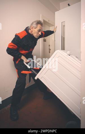 Ein älterer Mann in der Waschmaschine auf dem Wagen mit Aufzug Stockfoto