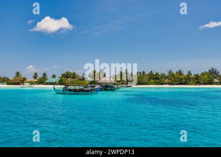 Inspirierendes Stranddesign auf den Malediven. Malediven traditionelles Boot Dhoni und perfektes blaues Meer mit Lagunenbucht. Luxuriöses tropisches Resort Hotel Paradies Küste Stockfoto