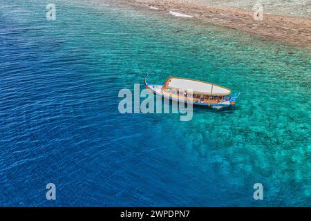 Strand und kristallklare Lagune mit weißem Boot. Türkisfarbener Wasserhintergrund, Draufsicht. Sommerlandschaft aus der Luft. Draufsicht von der Drohne. Sommerurlaub Stockfoto