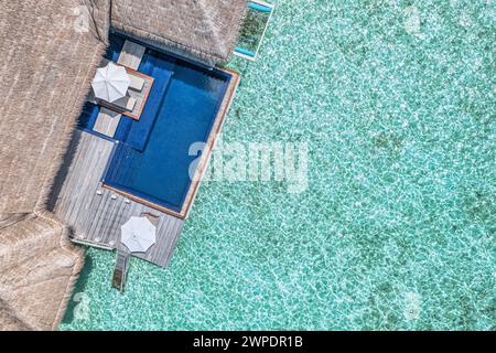 Strandresort aus der Luft. Minimalistischer Infinity-Pool mit Blick auf den Strand und der blauen Lagune mit wunderschönen Wellen und Wellen. Luxusreisen Stockfoto