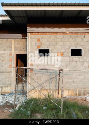 Altes Gerüst, das für die Verputzung der Rückseite eines im Bau befindlichen Hauses auf dem Land verwendet wurde, Vorderansicht mit dem Kopierraum. Stockfoto