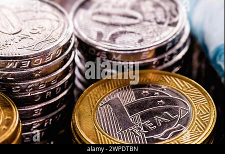 Nahaufnahme von brasilianischen Münzen und 100 Reais-Banknoten, Hintergrundbild mit Finanzierungskonzept, Wirtschaft brasiliens oder Lotterie. Stockfoto