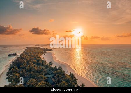 Sonnenuntergang über dem wunderschönen tropischen Strand der Malediven. Fantastisches farbenfrohes Meer Himmel Bucht Wasser, Palmen Sandstrand. Luxusvillen Resort, Reise Stockfoto
