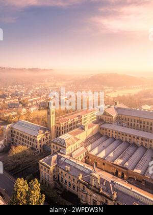 Atemberaubende Aussicht über Saltaire und Salts Mill, eine ehemalige viktorianische Textilmühle, die von Titus Salts erbaut wurde, bei Sonnenaufgang an einem nebeligen Morgen. Eine UNESCO-Welt. Stockfoto