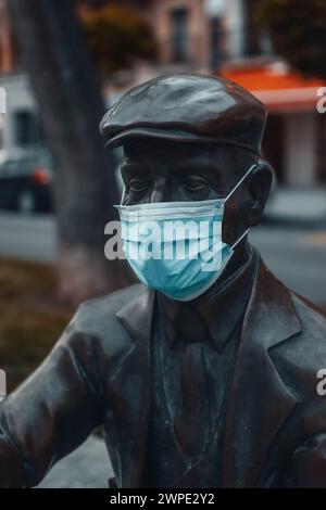 Statue der älteren Virgili auf der Rambla Nova in Tarragona, mit einer Maske wegen COVID-19. Stockfoto