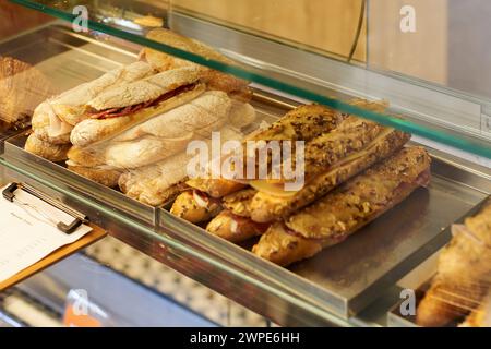 Appetitliche handwerkliche Sandwiches, die in einer Delikatessenvitrine verkauft werden können. Stockfoto