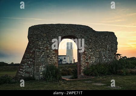 Cliff Parade, Hunstanton, Norfolk, England, Vereinigtes Königreich, Sonnenaufgang - Leuchtturm von Hunstanton durch einen Bogen in den Ruinen der St. Edmund Kapelle Stockfoto