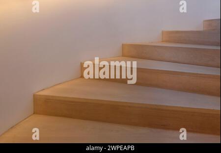 Hölzerne Treppen, die nach oben führen, von der Seite beleuchtet Stockfoto