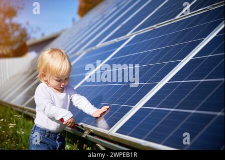 Ein kleines Kind lernt, wie man Werkzeuge benutzt. Kleines Kind, das untersucht, wie Solarbatterien funktionieren. Neugieriger Junge, der an Reparaturen interessiert ist. Stockfoto