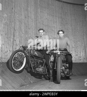 Mauer des Todes 1949. Die Mauer des Todes, das Motordrome, das Velodrome oder der Brunnen des Todes ist eine Nebenausstellung des Karnevals mit einem silos- oder tonnenförmigen Holzzylinder mit einem Durchmesser von normalerweise 6,1 bis 11,0 m (20 bis 36 Fuß) und aus Holzdielen, in der Motorradfahrer entlang der vertikalen Wand fahren und Stunts durchführen. durch Reibung und Zentrifugalkraft gehalten. Die ursprüngliche Mauer des Todes befand sich 1911 auf Coney Island in den Vereinigten Staaten. Ich habe mir einen Motorradfahrer in hoher Geschwindigkeit im Velodrome vorgestellt, der mit den Händen in der Luft zeigte, nicht wie er sollte am Lenker. Schweden 1947. Conard Stockfoto