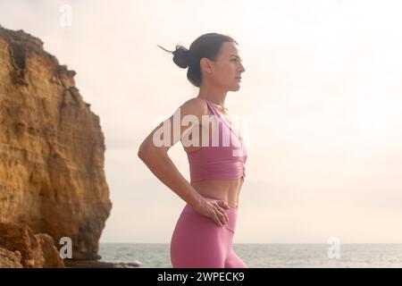 Frau mit Sportkleidung am Meer. Vorbereitung vor dem Schwimmen im offenen Wasser Stockfoto