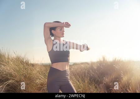 Sportliche Läuferin, die ihre Smartwatch auf Puls überprüft Stockfoto