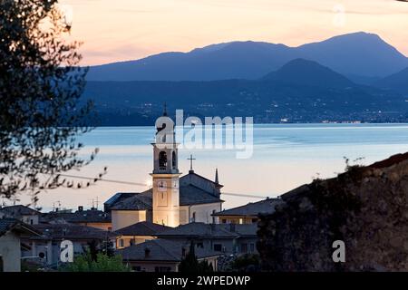 Das Dorf Torri del Benaco mit der Kirche San Pietro e Paolo. Im Hintergrund Gardasee. Veneto, Italien. Stockfoto