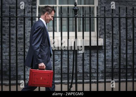 London, Großbritannien. März 2024. Jeremy Hunt, Parlamentsabgeordneter, Chancellor of the Exchequer, geht entlang der Downing Street, nachdem er die rote Versandkiste mit dem Frühjahrsbudget enthüllt hat, bevor er sie dem Parlament vorlegt. Unerwarteterweise kehrte Hunt kurzzeitig in Nr. 11 zurück und verließ dann, anders als in früheren Jahren, wieder über Nr. 10. Quelle: Imageplotter/Alamy Live News Stockfoto