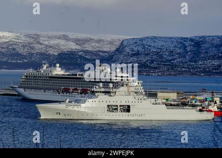 Alta 20240307. Jan Mayen-Klasse KV Bjørnøya (W 311) der Küstenwache im Zusammenhang mit der Militäraktivitätsübung Nordic Response. Dahinter befindet sich das Kreuzfahrtschiff Viking Venus von Viking Viking Ocean Cruises. Über 20.000 norwegische und alliierte Soldaten aus 13 Ländern werden gemeinsam trainieren, um die nordische Region zu verteidigen. Die Soldaten kommen aus Belgien, Kanada, Dänemark, Finnland, Frankreich, Italien, Niederlande, Norwegen, Spanien, Großbritannien, Schweden, Deutschland und die USA. Die norwegische Militärübung „Cold Response“ hat eine lange Geschichte und findet alle zwei Jahre in Nordnorwegen statt. Aufgrund der NATO-Erweiterung Stockfoto