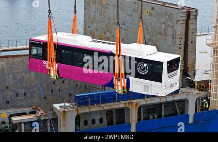 QINGDAO, CHINA – 7. MÄRZ 2024 – Ein neuer Energiebus wird am 7. März 2024 im Hafen Qingdao in der Provinz Shandong auf ein Schiff gebracht. Am selben Tag 53 Domesti Stockfoto