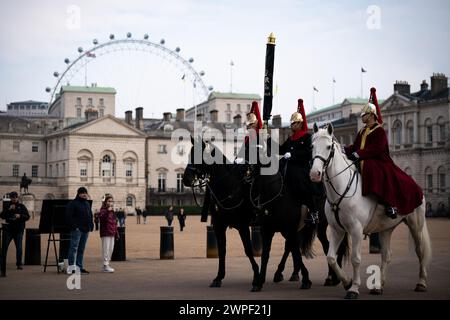 Touristen beobachten Mitglieder der Blues und Royals von der Household Cavalry auf der Horse Guards Parade in London. Bilddatum: Donnerstag, 7. März 2024. Stockfoto