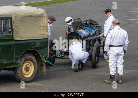 Nicholas Pellett wurde 1914 in seinem Sunbeam Tourist Trophy Car von Marshals beim S.F. Edge Trophy Rennen in Goodwood 80MM, Sussex, Großbritannien, unterstützt. Stockfoto