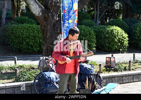 Peruanischer Musiker, der Panflöten und einen Charango im ueno Park spielt – Taito, Tokio, Japan – 28. Februar 2024 Stockfoto