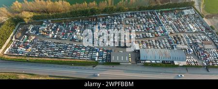 Luftaufnahme des großen Parkplatzes von Schrottplatz mit Reihen von weggeworfenen gebrochenen Autos. Recycling von Altfahrzeugen Stockfoto