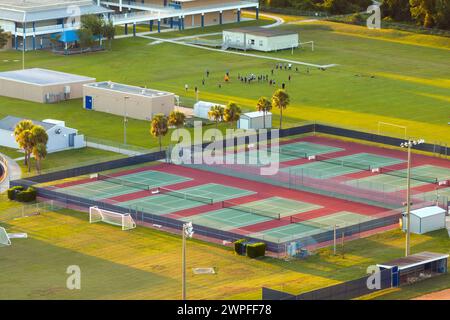 Tennisplatz im Hinterhof der amerikanischen öffentlichen Schule für Sportunterricht im ländlichen Florida. Sportinfrastruktur im Freiluftballpark Stockfoto