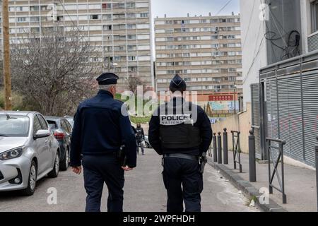 Marseille, Frankreich. Februar 2024. Zwei Polizisten, die von hinten gesehen werden, patrouillieren am 15. Februar 2024 in einem Wohngebiet in den nördlichen Vororten von Marseille. Foto: Laurent Coust/ABACAPRESS.COM Credit: Abaca Press/Alamy Live News Stockfoto