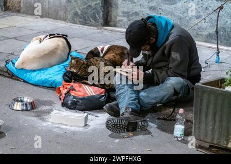 Catania, Italien - 2. März 2024: Obdachloser auf der Straße mit seinen Tieren, Hunden und Katzen in der Stadt Catania in Italien *** Obdachloser am auf der Straße mit seinen Tieren, Hunde und Katze in der Stadt Catania in Italien Stockfoto