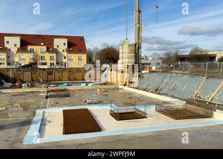Baustelle mit Beginn der Fundamentarbeiten eines großen Gebäudes.Turmkran und vorbereitete Metallbeschläge. Stockfoto