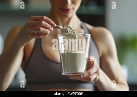 Junge Frau in Sportbekleidung Zubereitung Kochen Cocktail gesunde Ernährung Protein energetische Sport Ergänzungen Frühstück Antioxidans Fitness Schlankheitspflege Stockfoto