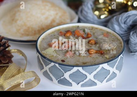 Köstlicher und gesunder Hühnereintopf. Ein herzhafter Eintopf mit gekochten Hähnchenstücken, Karotten, Kartoffeln, Erbsen und Kräutern, serviert zusammen mit traditionellem Keral Stockfoto