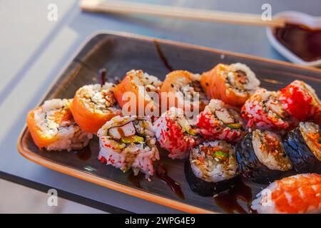 Aus nächster Nähe sehen wir verschiedene Sushi auf dem Tisch im Restaurant, serviert auf einem speziellen Sushi-Tablett. Curacao. Stockfoto