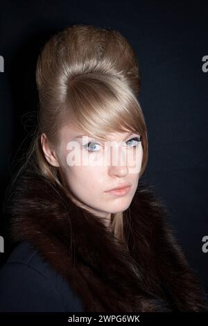 Blondes Mod Girl mit Bienenstock-Frisur, die in die Kamera schaut Stockfoto