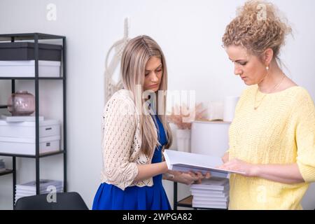 Zwei professionelle Frauen diskutieren über ein Buch und schlagen Zusammenarbeit, Strategie und Unternehmensanalyse in einem Büroumfeld und in der Planung vor. Hallo Stockfoto