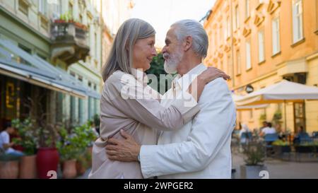 Träumender älterer kaukasischer Erwachsener reifes grauhaariges Paar Frau Mann, der Kamera sieht, lächelnd umarmt, knuddelt, denkt nach einer guten Zukunft draußen. Medizin Stockfoto