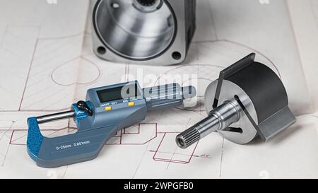 Blaues Mikrometer-Schraubmaß und Metallteile auf technischem Zeichnungshintergrund. Großaufnahme des Messwerkzeugs, des Stahlrotors und des Stators des Pumpenschieberkompressors Stockfoto