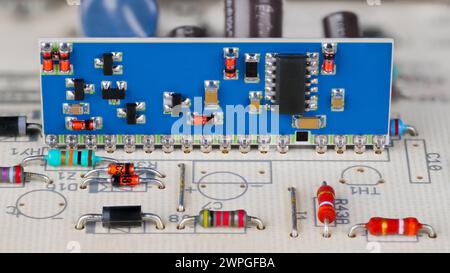 Integrierte Schaltung und SMD-Elektronikkomponenten auf einer blauen Leiterplatte. Nahaufnahme eines Hybridmoduls auf weißer Leiterplatte. Automatische Steuerung. Stockfoto