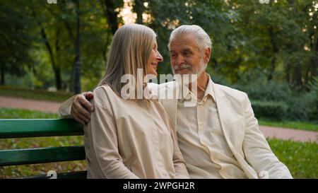 Reizende ältere ältere ältere Menschen glückliches kaukasisches Paar Frau Mann, der kuschelt romantisches Date während des Ruhestandsflirts annimmt, um den Familienjubiläum draußen zu feiern Stockfoto