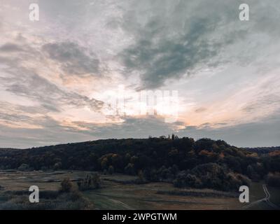 Luftatmosphäre stimmungsvolle, ländliche Herbstlandschaft mit wolkengrauem Himmel, Feldweg in Feldern und Wald Stockfoto