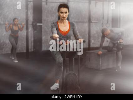 Frau mittleren Alters beim Cardio-Training auf dem Fahrrad-Ellipsoid. Funktionales Trainingskonzept Stockfoto