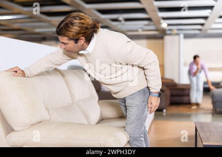 Der Mann überprüft die hohe Qualität des Sofas Stockfoto