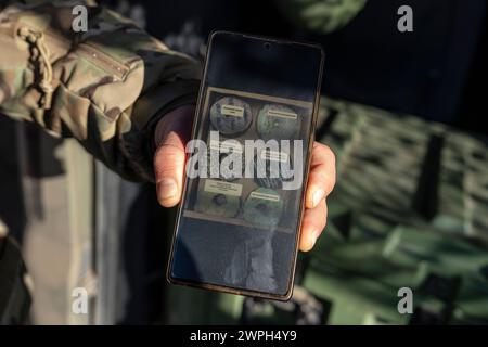 Donbass, Ukraine. März 2024. Ein Mitglied der ukrainischen Aufklärungsdrohne „Leleka“ von der 80. Luftangriffsbrigade zeigt auf seinem Handy ein Foto von Donuts, das er bei dem Bäcker machte, den er vor seinem Einstieg in die Armee besaß, an einer Stelle im Donbass. Drohnen sind ein wesentlicher Bestandteil der Kriegsführung, seit Russland am 24. Februar 2022 seine Invasion in der Ukraine begann. (Foto: Laurel Chor/SOPA Images/SIPA USA) Credit: SIPA USA/Alamy Live News Stockfoto