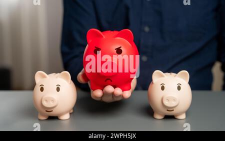 Rot aufgeblähte Schweinebank vor dem Hintergrund normaler. Überhitzter Finanzmarkt. Übersättigung der Mittel und Beschleunigung der Inflation. Heav Stockfoto