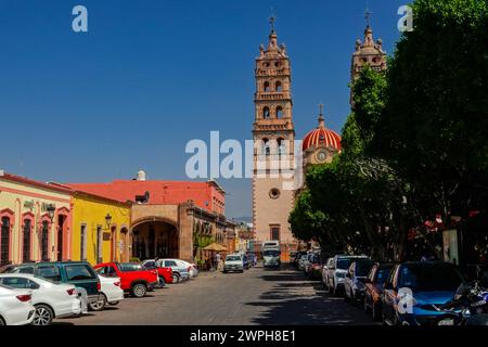 Die Zwillingstürme der Pfarrkirche Nuestra Señora de la Luz oder der Kirche unserer Lieben Frau vom Licht auf der Calle 16th de Septiembre und der Park Jardin de Salvatierra im zentralen historischen Viertel von Salvatierra, Guanajuato, Mexiko. Die neogotische Kirche aus dem 17. Jahrhundert ehrt die Patronin der Stadt. Stockfoto