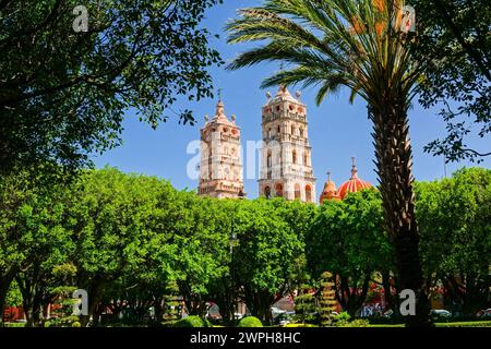 Die zwei Glockentürme der Pfarrkirche Nuestra Señora de la Luz oder der Kirche unserer Lieben Frau vom Licht, die über den Jardin de Salvatierra Park im zentralen historischen Viertel von Salvatierra, Guanajuato, Mexiko, gesehen wird. Die neogotische Kirche aus dem 17. Jahrhundert ehrt die Patronin der Stadt. Stockfoto