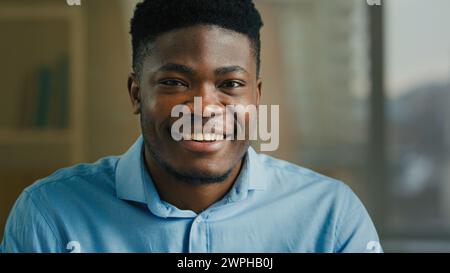 Kopfschuss afroamerikanischer Geschäftsmann ethnischer Kerl, der in die Kamera schaut glücklich lächelnder männlicher Multirassischer Mann Büromanager ceo Unternehmer Arbeitgeber Stockfoto