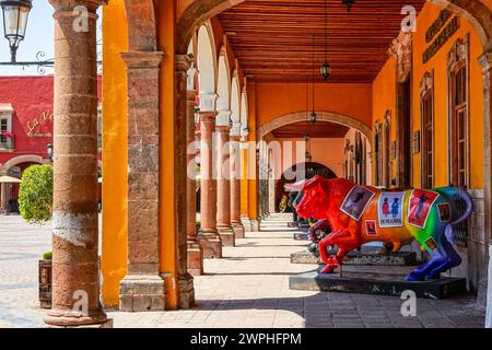 Individuell bemalte Statuen von Stieren säumen die Portales del Carmen entlang des zentralen historischen Viertels in Salvatierra, Guanajuato, Mexiko. Stockfoto