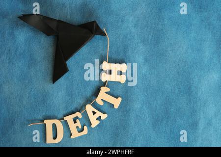 Botschaft des Todes Konzept. Schwarzer Rabe oder Krähenpapier Origami mit Todeswort. Stockfoto